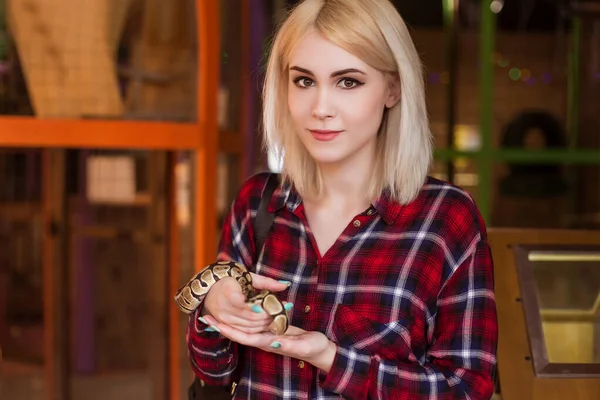 一个漂亮的金发女人手里拿着一条小的皇家蟒蛇 联络动物园 — 图库照片
