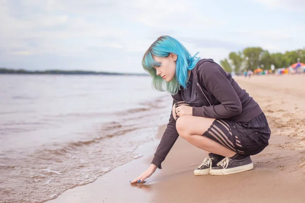 Hermosa Joven Sienta Playa Cálidamente Vestido Toca Temperatura Del Agua — Foto de Stock