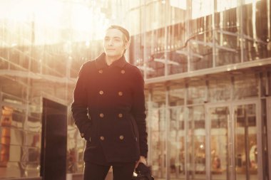 Cam bir binanın arka planında rastalı bir Amerikalı çanta taşıyor, bir iş adamı. Yarım saat sonra, soğuk bir sonbahar sabahı.