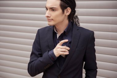 Takım elbiseli yakışıklı, genç bir adam cep telefonunu cebinden çıkardı. Rastalı adam, iş stili..