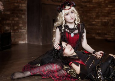 Şeytan, bir vampir güzel bir prenses kadının kucağında yatıyor. Gotik kostüm. Görsel Kei, aristokrat. Masal, fantezi. Peri masalı, hayal..