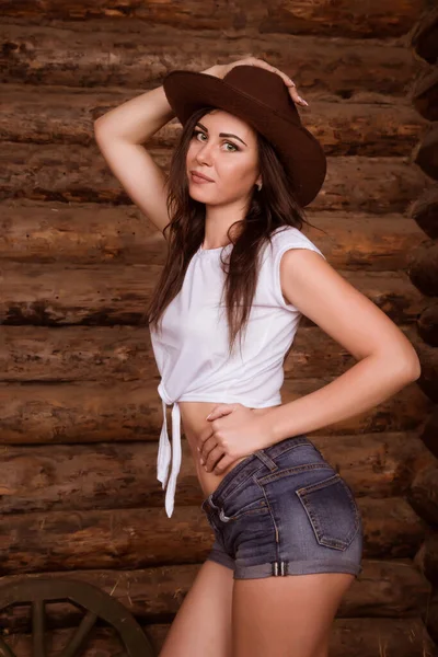 cowgirl in a barn smiling in denim shorts