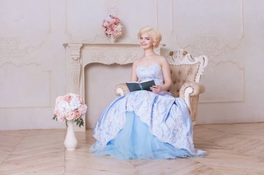 Genç bir kadın, bir kız kitap okurken elinde bir kitap tutuyor. Fransız prenses şöminenin yanındaki koltukta oturuyor, bir Versailles, asil bir bayan. Okuma, roman, şiir..