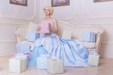 Çekici kız, sarışın kadın. Sindirella, kaledeki prenses. Mavi elbiseli zengin, beyaz bir kraliçe. Doğum günü, tatil, hediyeler, mutlu bir gülümseme..