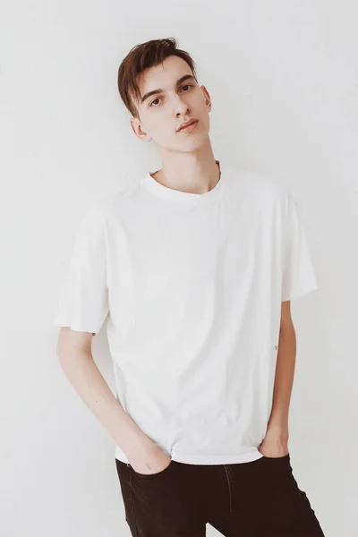 Hombre Joven Guapo Con Una Camiseta Blanca Apoyado Contra Pared — Foto de Stock