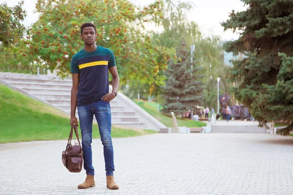 Negro Hombre Está Pie Parque Calle Sosteniendo Una Bolsa Mano —  Fotos de Stock