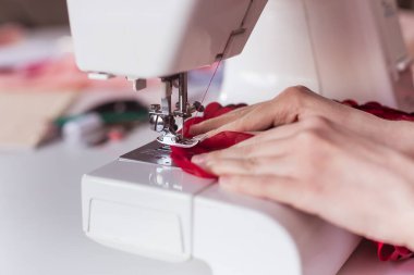 Dikiş makinesine terzinin yakın çekim görüntüsü. Dokuyu gerin..