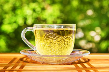 Yeşil arka plandaki masada bir fincan yeşil çay.