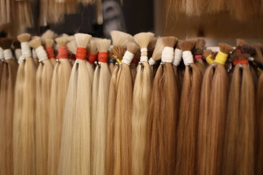Various colors of straight single clip in human hair extensions clipart
