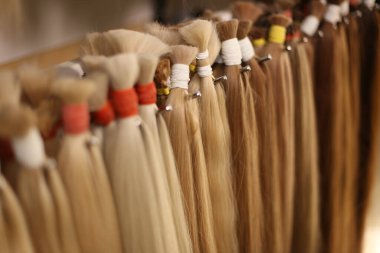 Various colors of straight single clip in human hair extensions. Making natural wigs. clipart