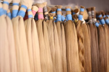Various colors of straight single clip in human hair extensions. Making natural wigs. clipart