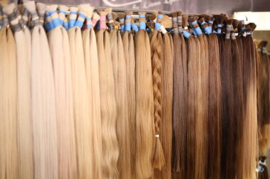 Various colors of straight single clip in human hair extensions clipart