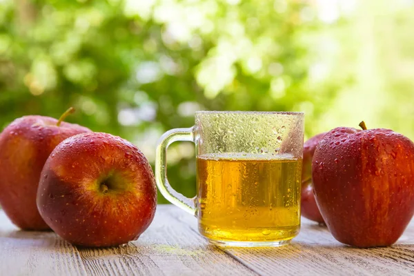 Elma Şarabı Verandada Meyve Suyu Tahtada Yeşil Arka Planda Kırmızı Stock Photo