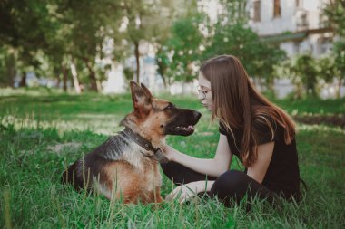 Parkta Alman çoban köpeği olan bir kadın. Retro tonlama.