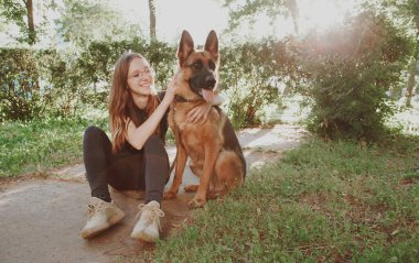 Parkta Alman çoban köpeği olan bir kadın.