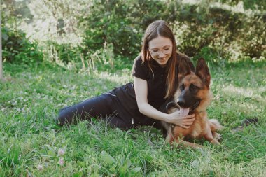Parkta Alman çoban köpeği olan bir kadın.