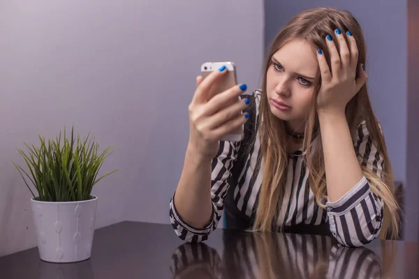 Piękna Młoda Kobieta Siedzi Przy Stole Trzyma Ręku Telefon Podpierający — Zdjęcie stockowe