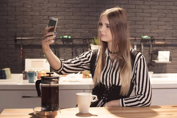 Genç Güzel Bir Kadın Mutfakta Oturmuş Bisküviyle Çay Içiyor Kendi Stock Image