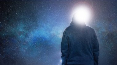 Looking up from behind at a mysterious, moody, hooded figure. With a universe and galaxy of stars in the background.