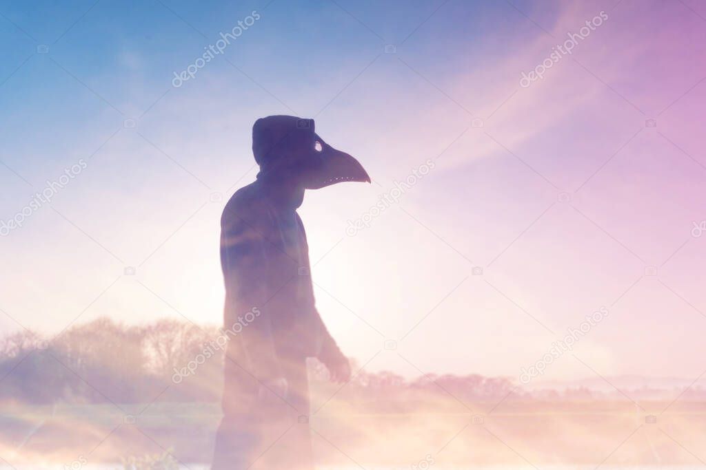 A double exposure of a moody, hooded figure with a plague doctor mask, silhouetted against the sunset. With an abstract, experimental dream like edit. 