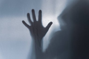 Yarı şeffaf bir maddeyi elle delen bir adam. Ürkütücü, bulanık, durgun bir hayat yaratmak.