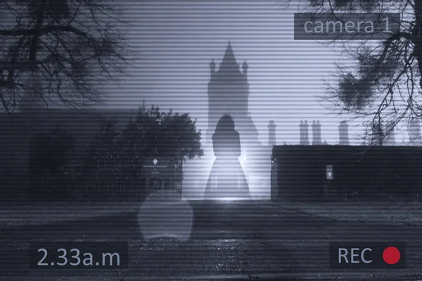 站在一座哥特式古塔前的一个飘浮的 透明的幽灵般的女人 在一个雾蒙蒙的冬夜 用闭路电视的监控编辑 — 图库照片