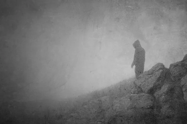 一个像梦一样的概念 一个头戴头罩 恐怖的人从雾蒙蒙的山岗向外张望 带着闷闷不乐的 古老的 质感十足的情调 — 图库照片