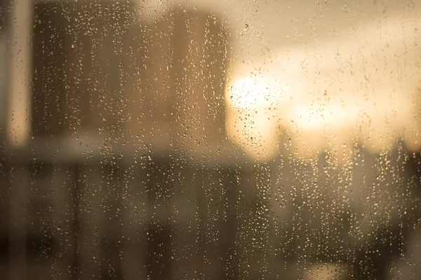 유리창에 빗방울입니다. 흐림 건물과 따뜻한 음색 — 스톡 사진