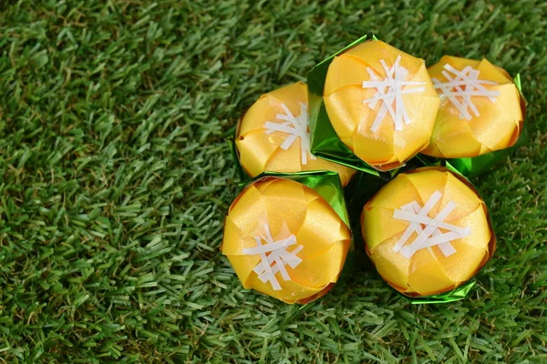 Kurdele ile katlama sikke Toddy palm kek (Khanom tan) koordinasyon töreni Budizm için yeşil çimenlerin üzerinde şeklinde / Khanom Tan popüler bir Tay tatlı.