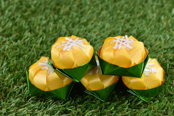 Kurdele ile katlama sikke Toddy palm kek (Khanom tan) koordinasyon töreni Budizm için yeşil çimenlerin üzerinde şeklinde / Khanom Tan popüler bir Tay tatlı.