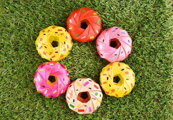 Kurdele ile katlama sikke donut koordinasyon dağılım töreni Budizm için yeşil çimenlerin üzerinde renkli bir grup şeklinde.