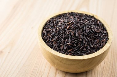 Yakın çekim kahverengi pirinç veya kase üzerinde ahşap doku sağlıklı riceberry organik gıda
