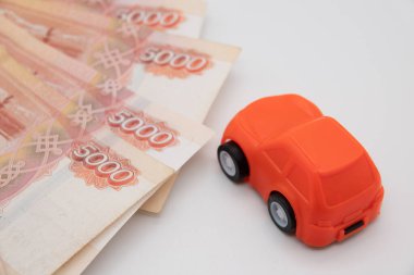 Banknotların arka planında oyuncak araba satın almak.