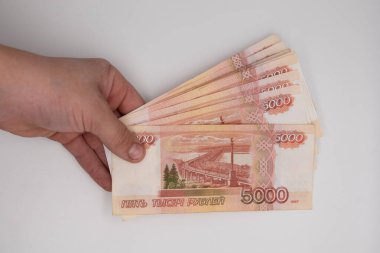 El ele tutuşan bir yığın Rus rublesi. Rusya 'nın parası 5000 banknot elinde..