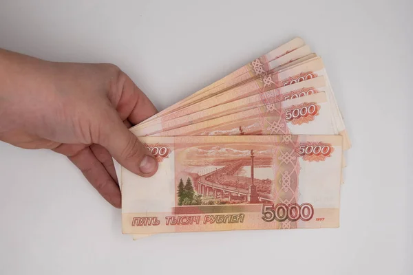 Hand holding stack of russian roubles. Russia money five thousand banknote hold in hands.