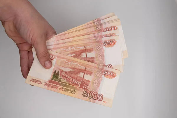 Handhållen hög med ryska rubel. Ryssland pengar fem tusen sedlar hålla i händerna. — Stockfoto
