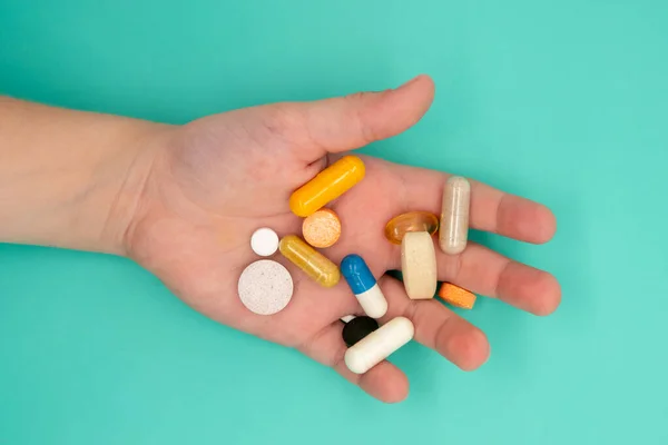 Sok tablettát kell bevenni a gyermek kezében, kék alapon — Stock Fotó