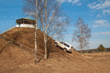 İlkbaharda 45 derecelik açıyla yokuş yukarı giden araba.