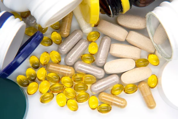 Vitaminok és omega-3, tőkehalmáj - olaj, étrend-kiegészítő tabletta a töltésen, a világos háttér közelről — Stock Fotó
