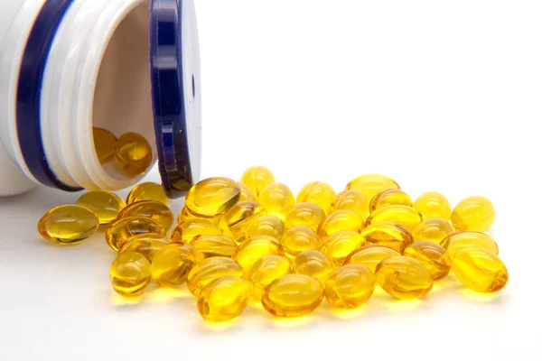 Beyaz arka planda balık yağı kapsüllerini kapatın. Beyaz zemin üzerinde birçok D32000 liu vitamini kapsülü.