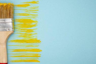 Sarı boya ve fırça izi. Mavi arka plan. Metnin için alanı boşlukla kapat