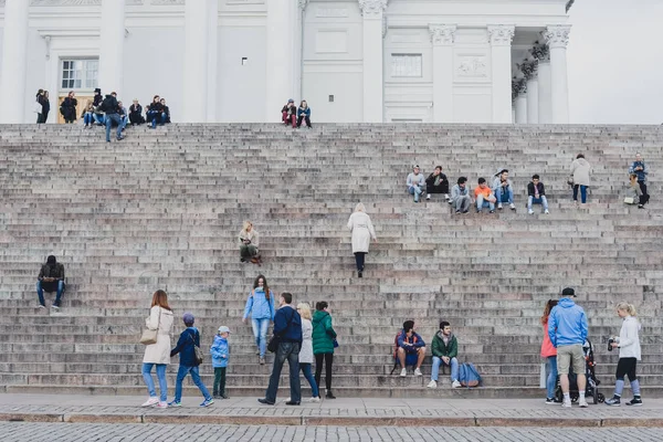 HELSINKI, FINLÂNDIA - CIRCA SETEMBRO 2016: as pessoas se sentam nas escadas da catedral evangélica luterana finlandesa em Helsinque, Finlândia, por volta de setembro de 2016 . — Fotografia de Stock
