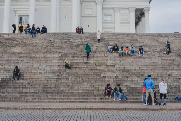 HELSINKI, FINLÂNDIA - CIRCA SETEMBRO 2016: as pessoas se sentam nas escadas da catedral evangélica luterana finlandesa em Helsinque, Finlândia, por volta de setembro de 2016 . — Fotografia de Stock