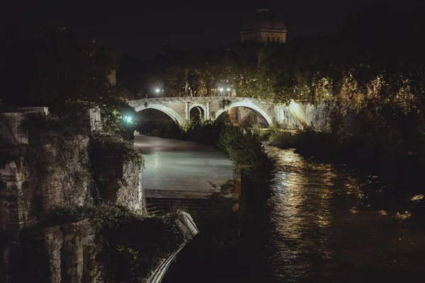 Rom, Italien - Circa oktober 2016: utsikt över floden och arch bridge i historiskt centrerar av Rome, Italien från toppen av kullen på natten ca oktober 2016. — Stockfoto