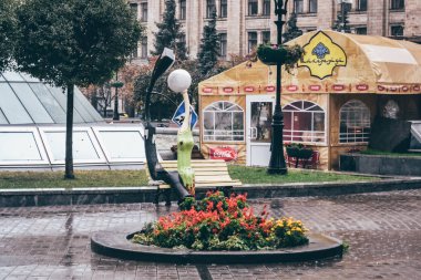 Kiev, Ukrayna - Ekim 2011 yaklaşık: Kiev, Ukrayna cicra Ekim 2011 eski kasabasında bankta iki sokak fener ile bir heykel.