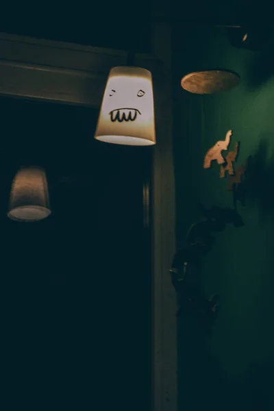 Funny indoors lantern with a scary face painted on it by the window at night time. — Stock Photo, Image