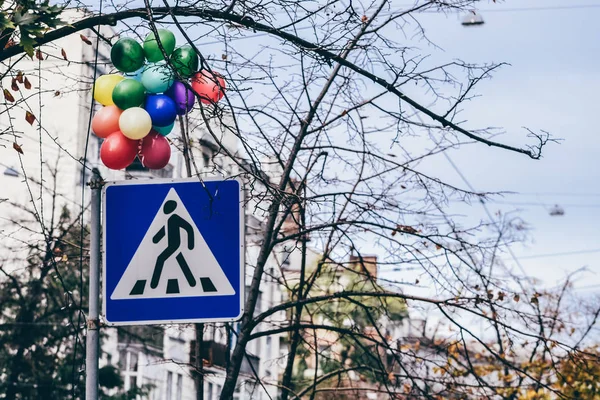 KIEV, UKRAINE - CIRCA OCTOBER 2011: road sign of a pedestrian crossing with a bunch of many-colored baloons in the old town in Kiev, Ukraine cicra October 2011. — Stock Photo, Image
