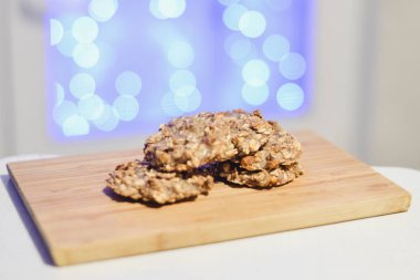 Sağlıklı şekersiz ve un ücretsiz muz ve festival arka ışıkları ile ahşap bir gemide yulaf ezmeli kurabiye.