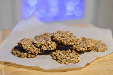 Sağlıklı şekersiz ve un ücretsiz muz ve festival arka ışıkları ile ahşap bir gemide yulaf ezmeli kurabiye.