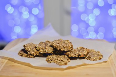 Sağlıklı şekersiz ve un ücretsiz muz ve festival arka ışıkları ile ahşap bir gemide yulaf ezmeli kurabiye.